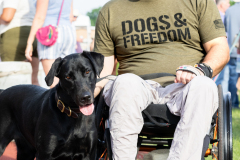 a man smiling with a black dog