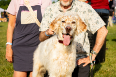 two people smiling with a dog